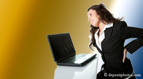a person Millville bending over a computer holding her back due to pain