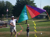 Millville back pain free grandpa and grandson playing with a kite